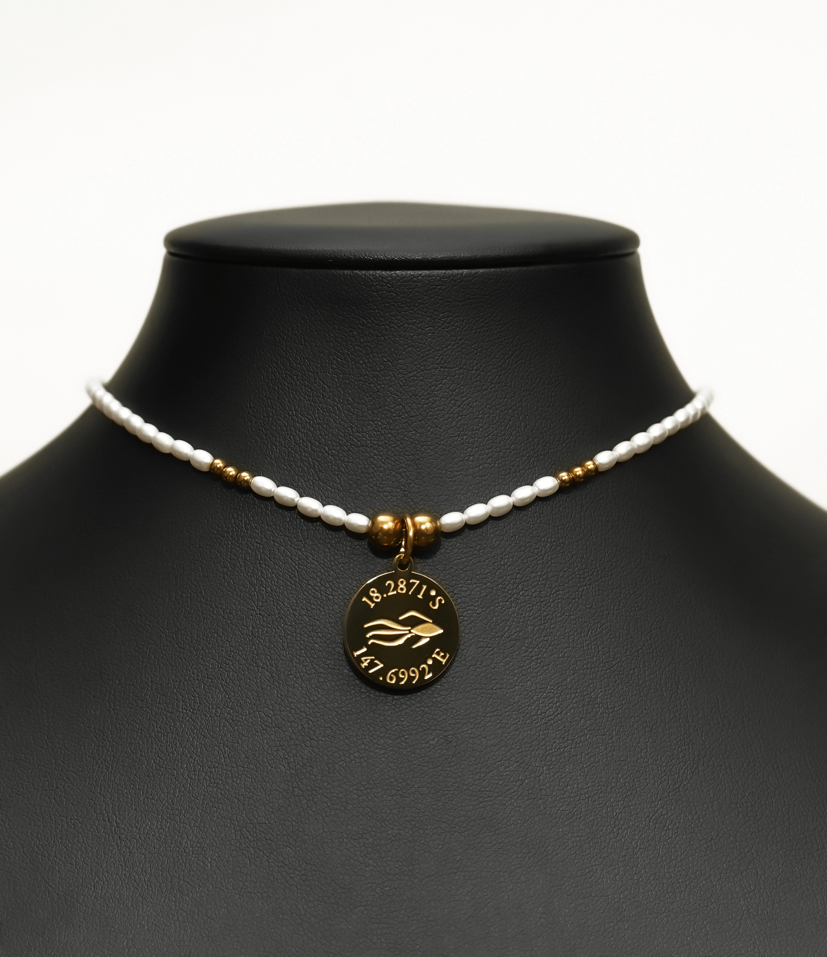 Aquarius Reef's 'Aquarius' choker - a white pearl and gold unisex beaded choker necklace from Aquarius Reef's Pearl collection, featuring a pendant with coordinates of the Great Barrier Reef.