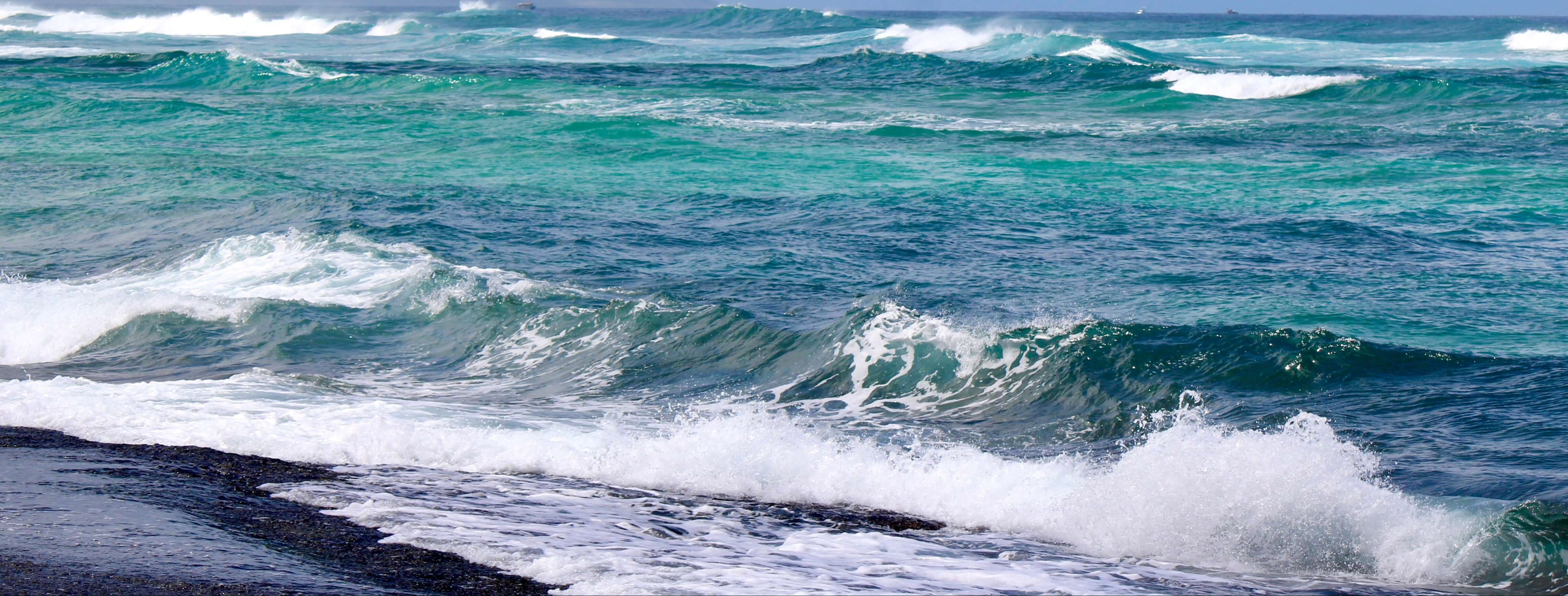 Photo of crashing waves by Aquarius Reef beaded choker necklaces.