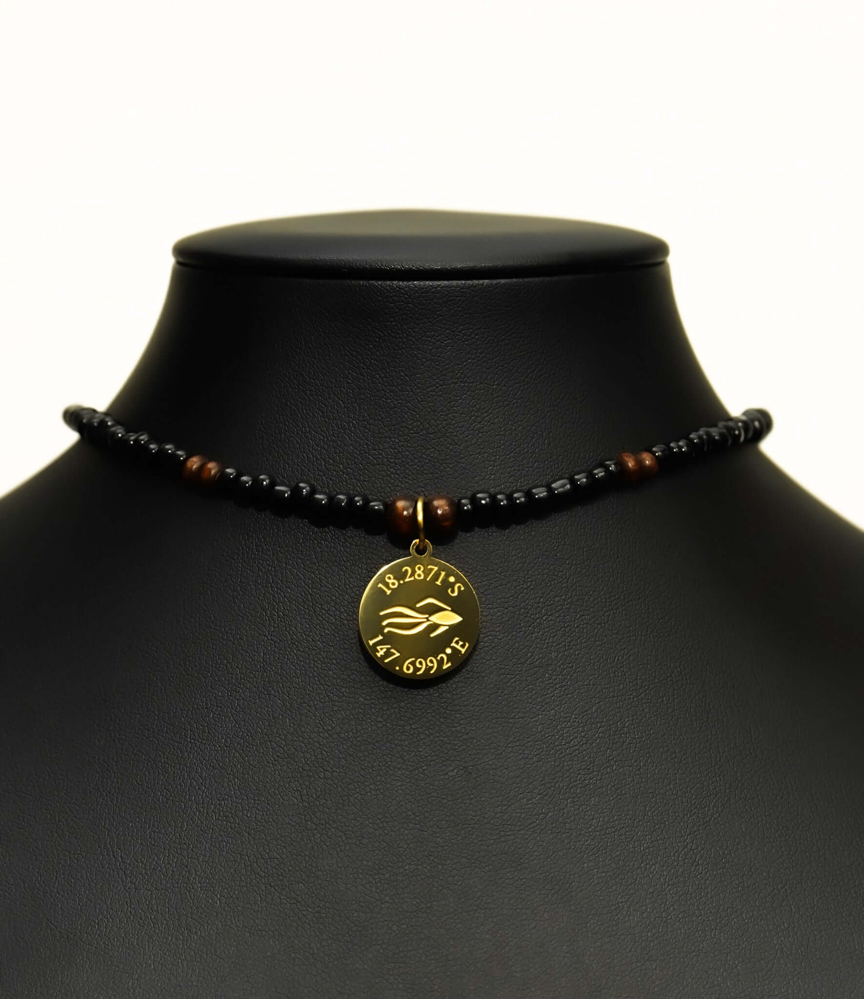 Aquarius Reef's gold 'Dare' choker - a black and gold unisex beaded choker necklace from Aquarius Reef's Classic collection, featuring a pendant with coordinates of the Great Barrier Reef.
