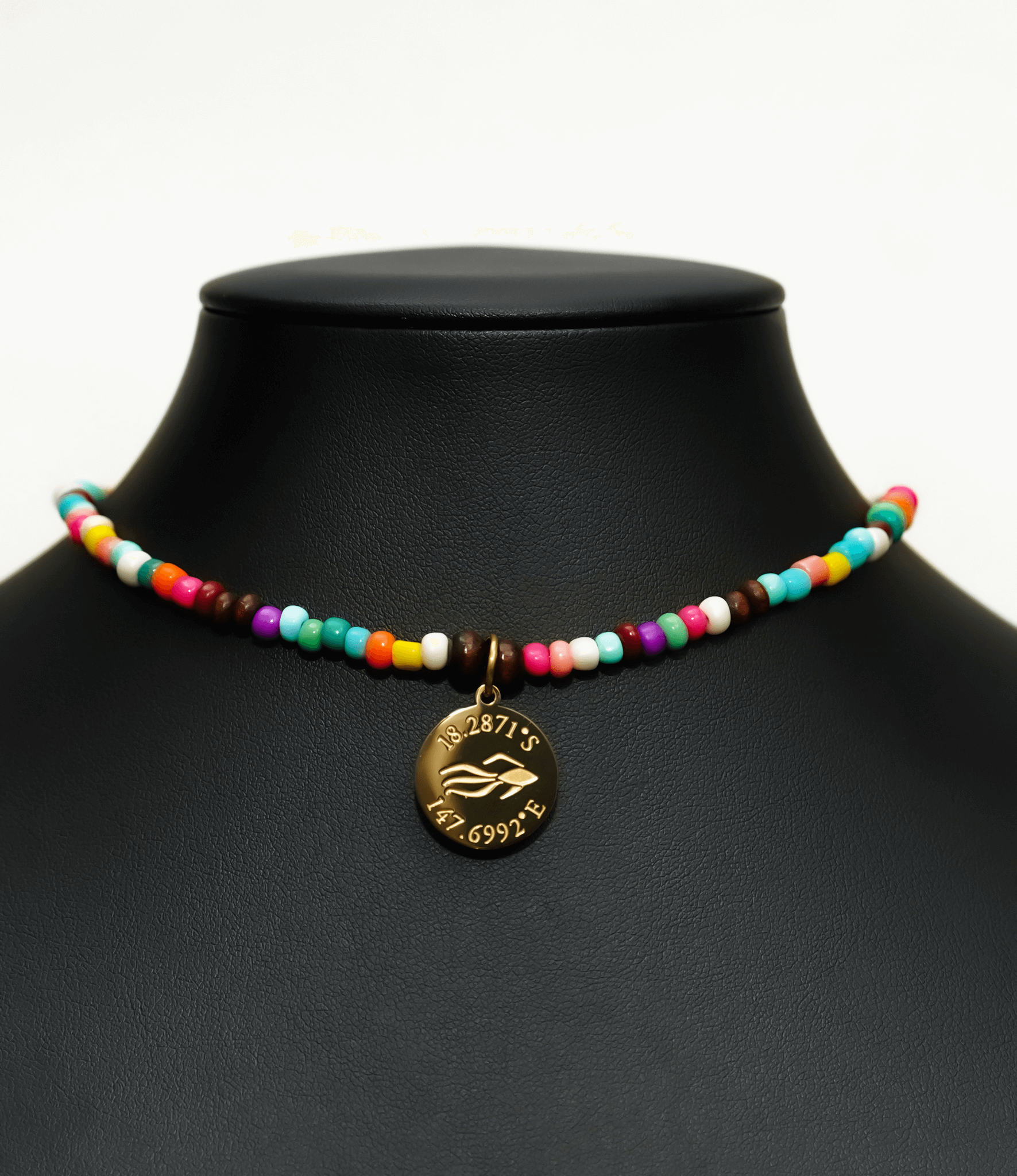 Aquarius Reef's gold 'Free' choker - a rainbow multicolor unisex seed beaded choker necklace in gold from Aquarius Reef's Edge collection, featuring a pendant with coordinates of the Great Barrier Reef. 
