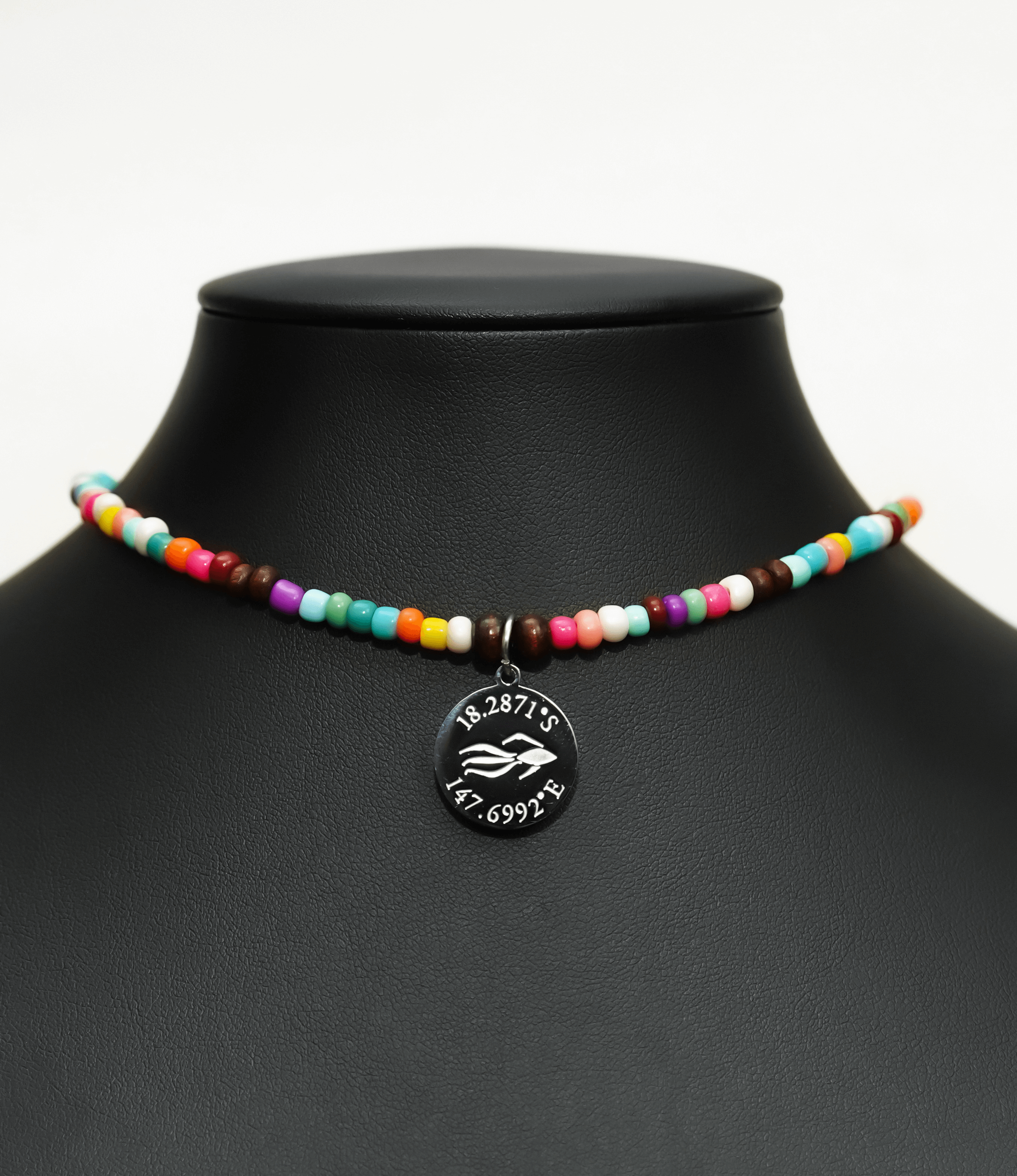 Aquarius Reef's silver 'Free' choker - a rainbow multicolor unisex seed beaded choker necklace in silver from Aquarius Reef's Edge collection, featuring a pendant with coordinates of the Great Barrier Reef.