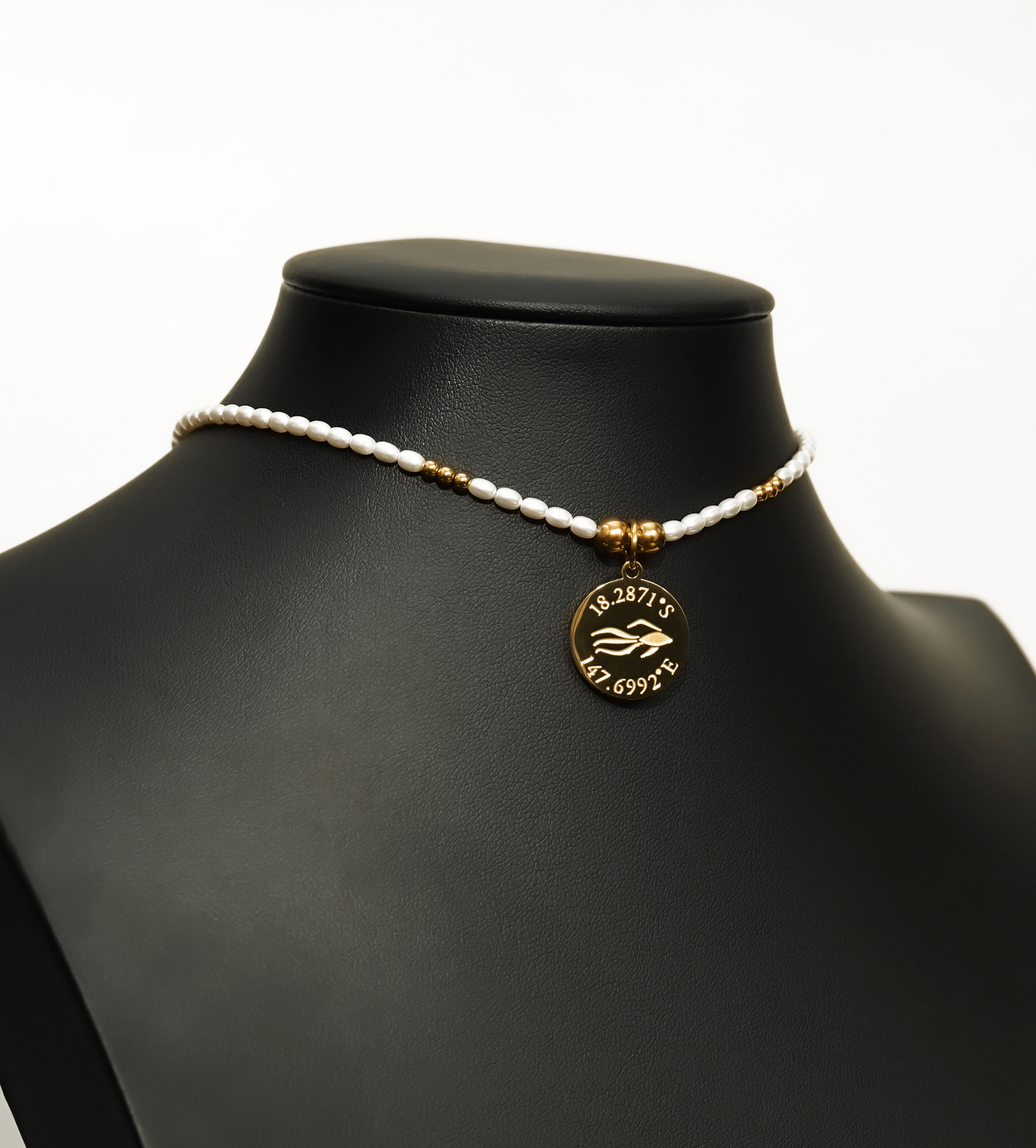 Aquarius Reef's 'Aquarius' choker - a white pearl and gold unisex beaded choker necklace from Aquarius Reef's Pearl collection, featuring a pendant with coordinates of the Great Barrier Reef.