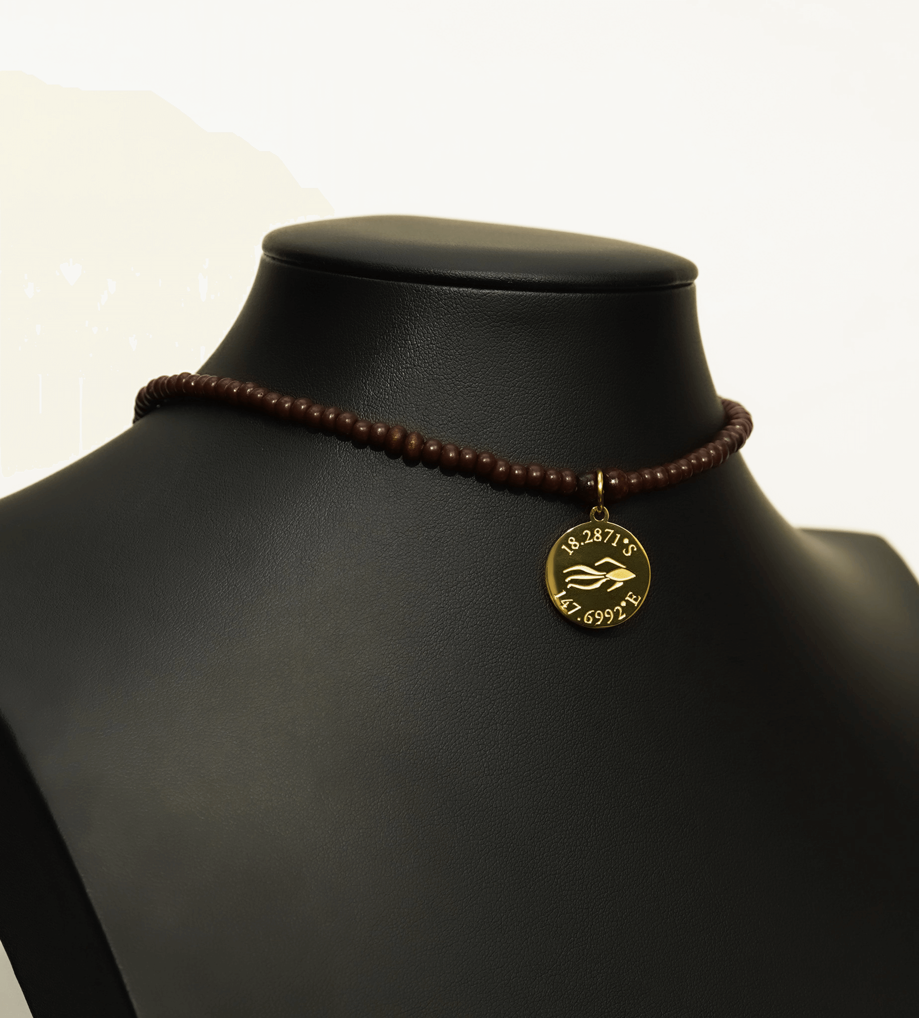 Aquarius Reef's gold 'Intimate' choker - a brown and gold unisex beaded choker necklace from Aquarius Reef's Classic collection, featuring a pendant with coordinates of the Great Barrier Reef.