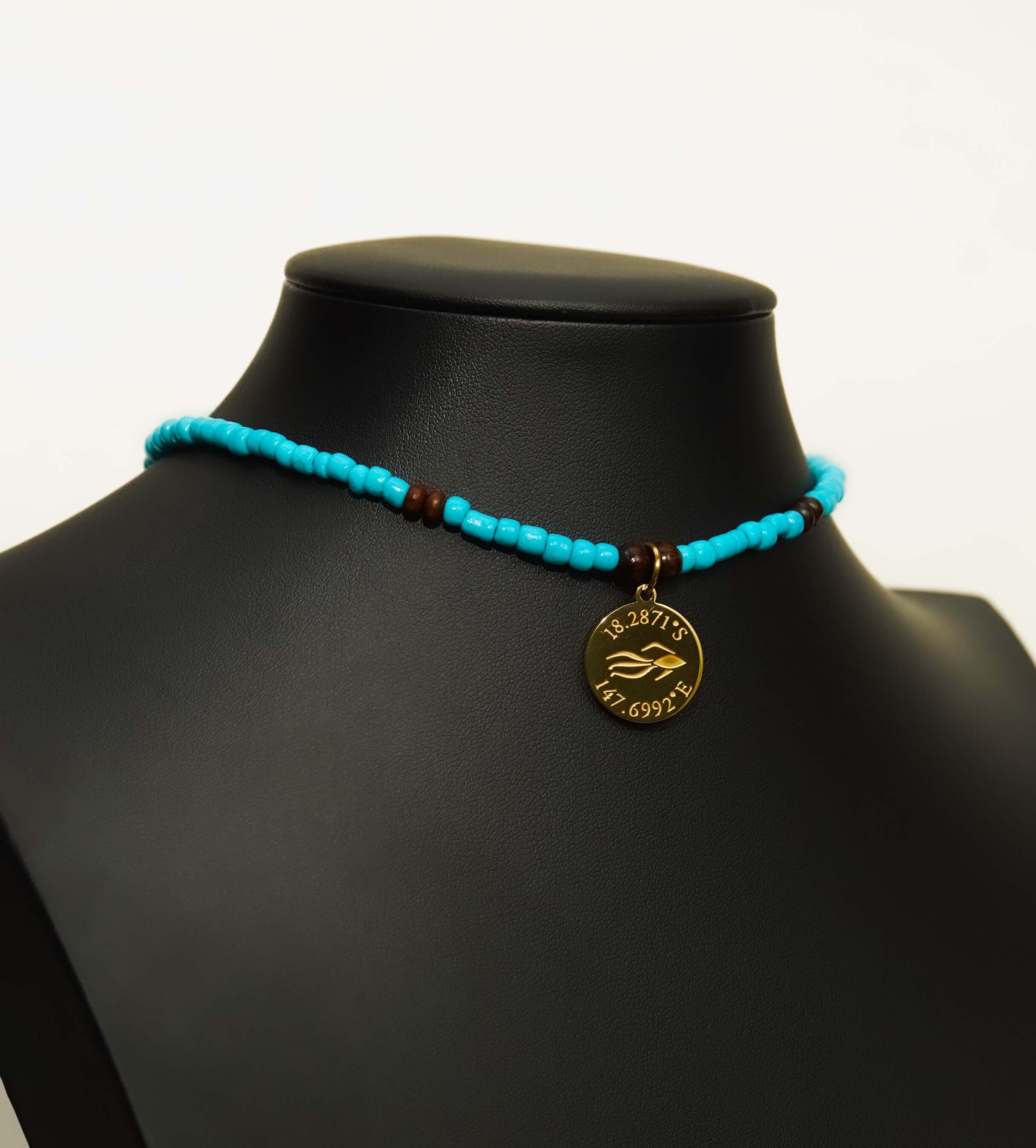 Aquarius Reef's gold 'Reef' choker - a turquoise and gold unisex beaded choker necklace from Aquarius Reef's Classic collection, featuring a pendant with coordinates of the Great Barrier Reef.