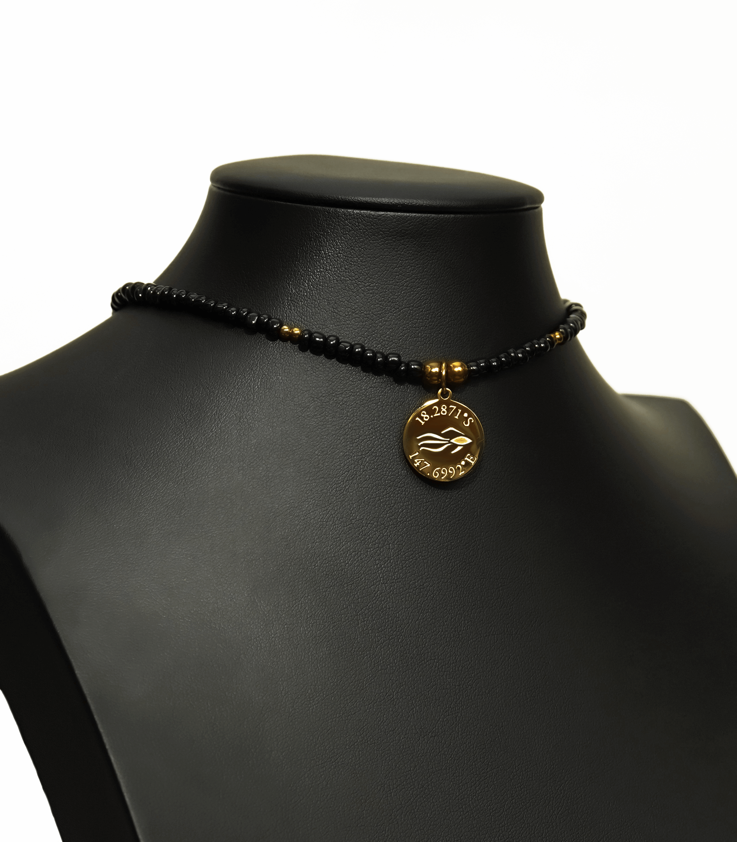 Aquarius Reef's gold 'Villain' choker - a black and gold unisex seed beaded choker necklace from Aquarius Reef's Edge collection, featuring a pendant with coordinates of the Great Barrier Reef.