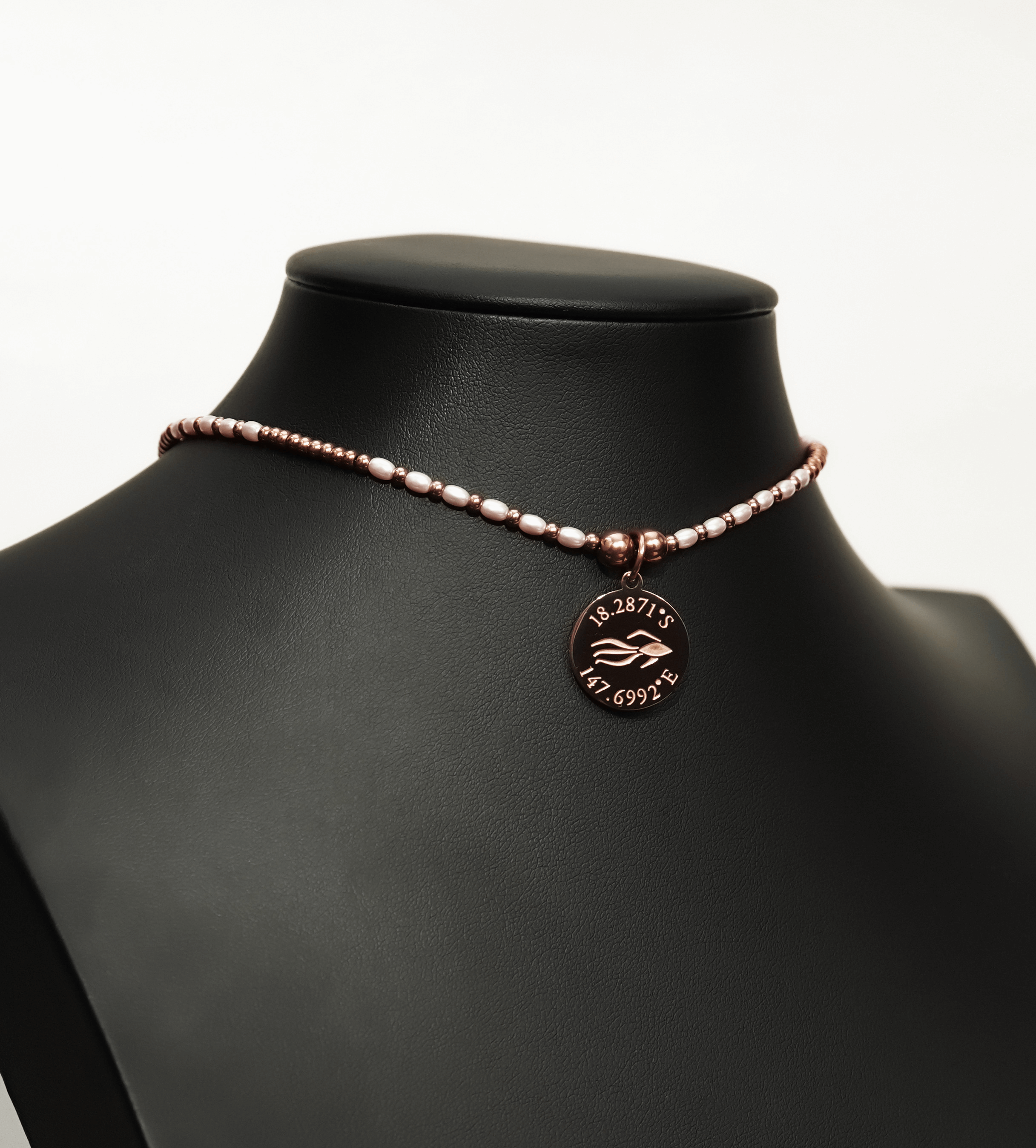 Aquarius Reef's pink pearl 'Aphrodite' choker - a pink pearl and rose gold unisex beaded choker necklace from Aquarius Reef's Pearl collection, featuring a pendant with coordinates of the Great Barrier Reef.