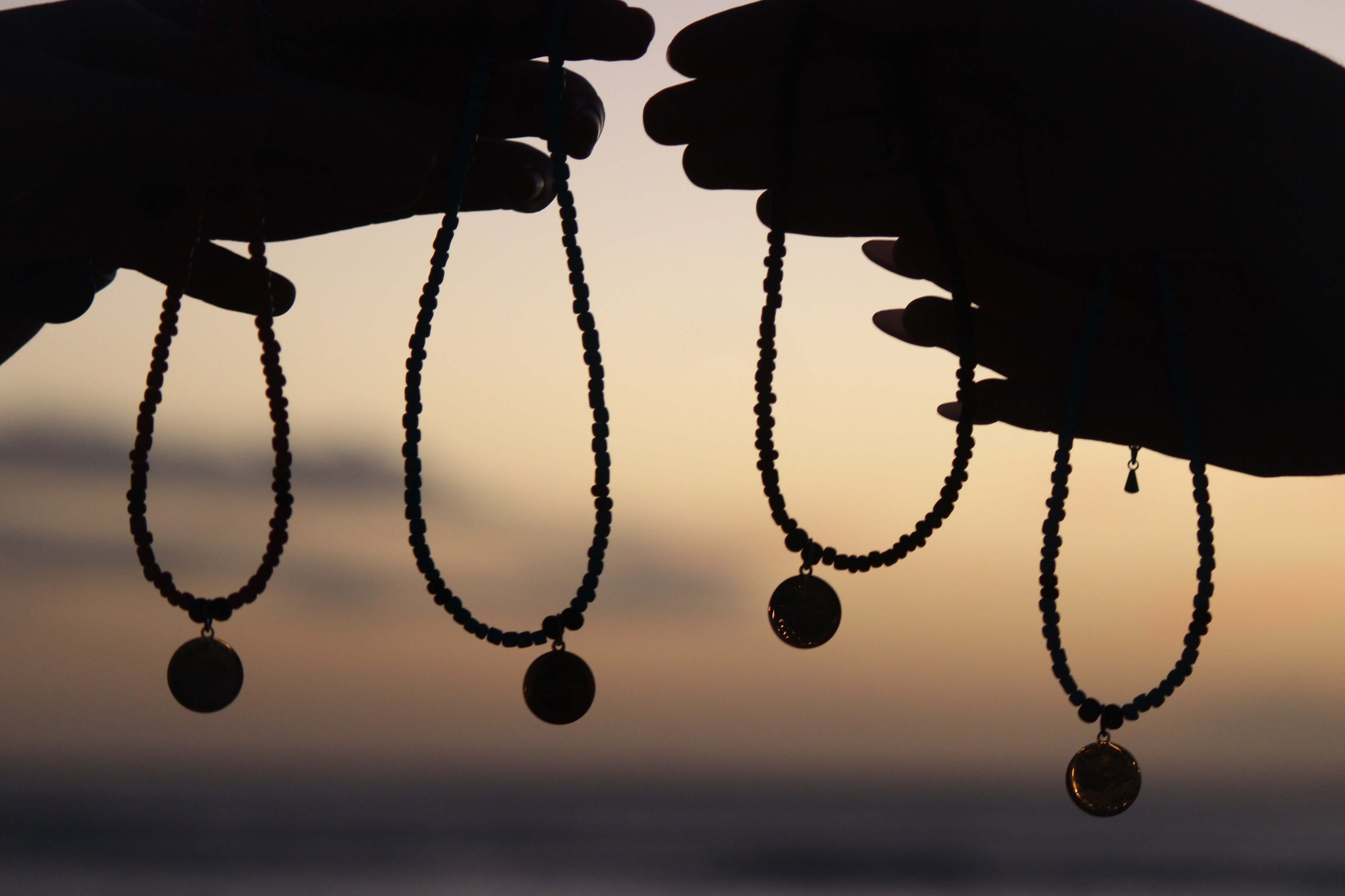 Photo of people holding up chokers  by Aquarius Reef beaded choker necklaces. 