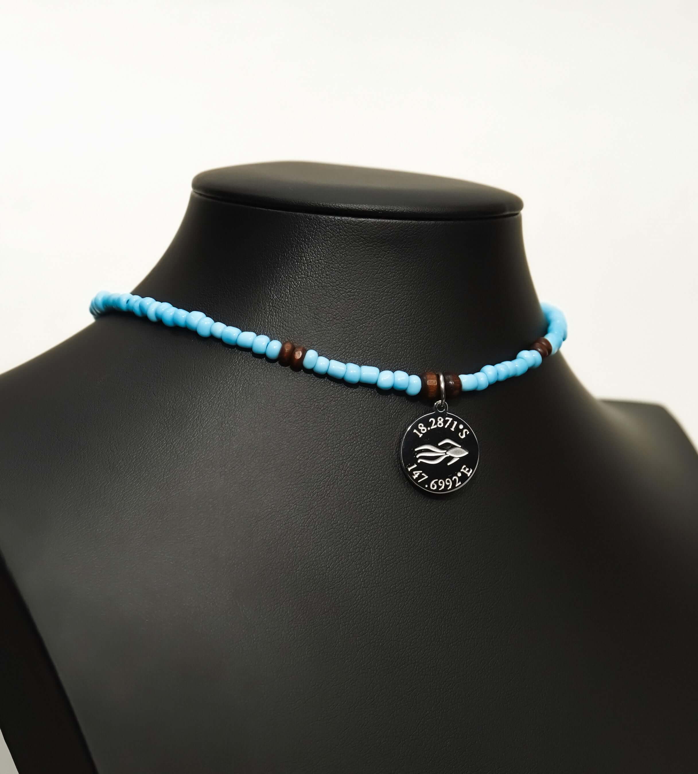 Aquarius Reef's 'West Coast' choker - a powder blue unisex beaded choker necklace in silver from Aquarius Reef's Classic collection, featuring a pendant with coordinates of the Great Barrier Reef.