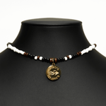 Aquarius Reef's gold 'Sparrow' choker - a black and white patterned unisex seed beaded choker necklace in gold from Aquarius Reef's Edge collection, featuring a pendant with coordinates of the Great Barrier Reef. 