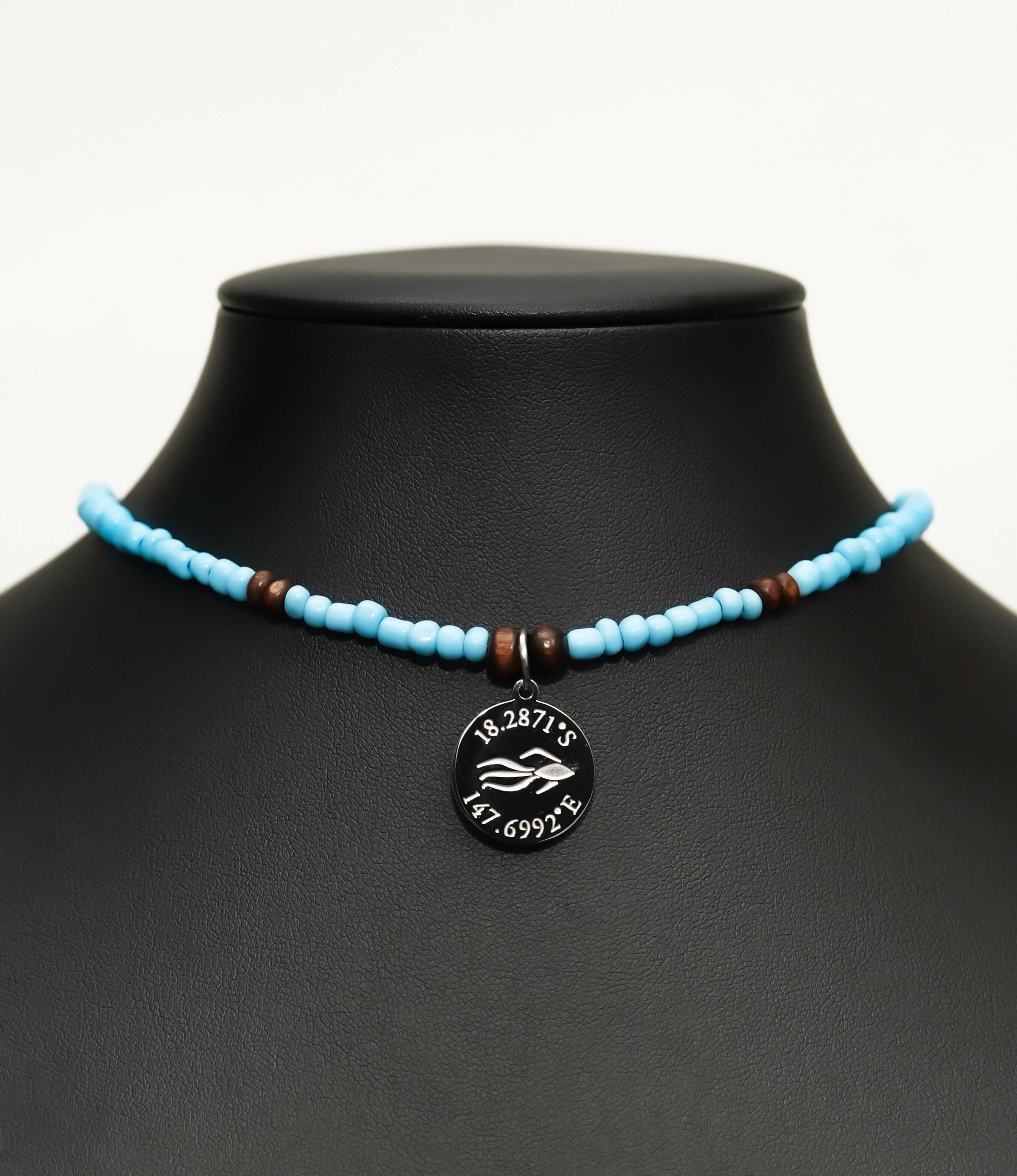 Aquarius Reef's 'West Coast' choker - a powder blue unisex beaded choker necklace in silver from Aquarius Reef's Classic collection, featuring a pendant with coordinates of the Great Barrier Reef.